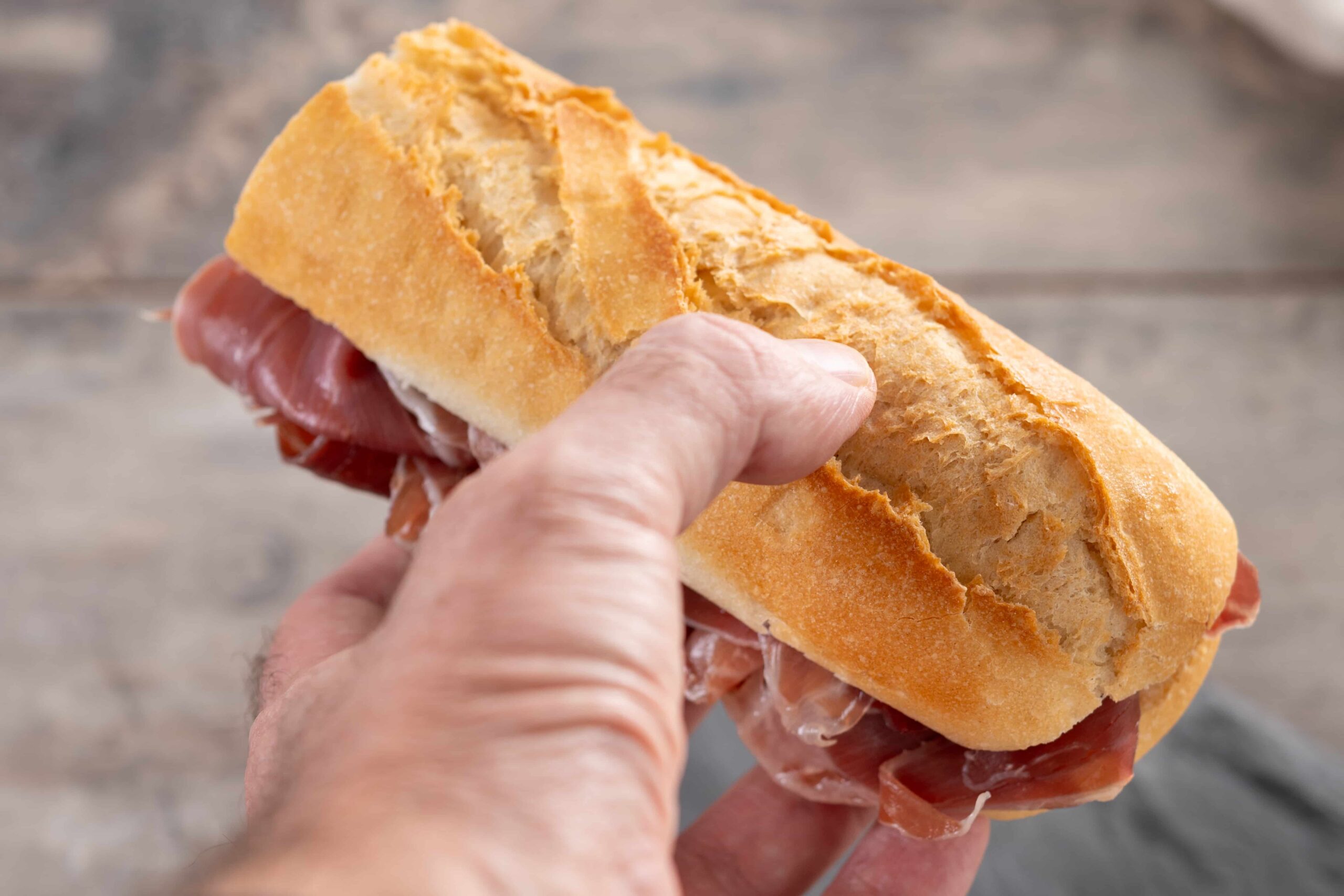 hand-holding-spanish-serrano-ham-sandwich